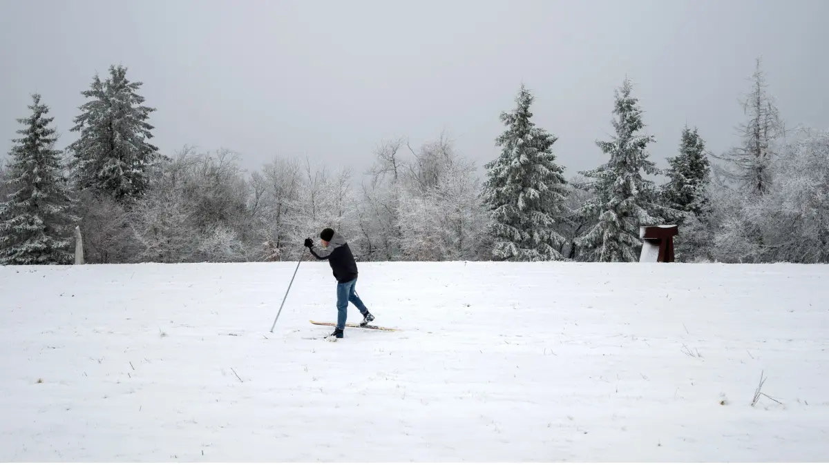 Ein Mann läuft auf Skiern über die dünne Schneedecke am Gipfel des Erbeskopf. Der Skilift ist noch nicht in Betrieb, Wintersport zur Zeit noch nicht möglich. +++ dpa-Bildfunk +++