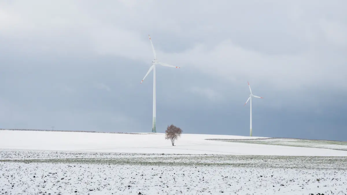 Schnee liegt bei Bösingen (Landkreis Rottweil) auf einem Feld, auf dem ein kleiner Baum und zwei Windkraftanlagen stehen. Im Schwarzwald werden bis zu 20 Zentimeter Neuschnee erwartet. +++ dpa-Bildfunk +++