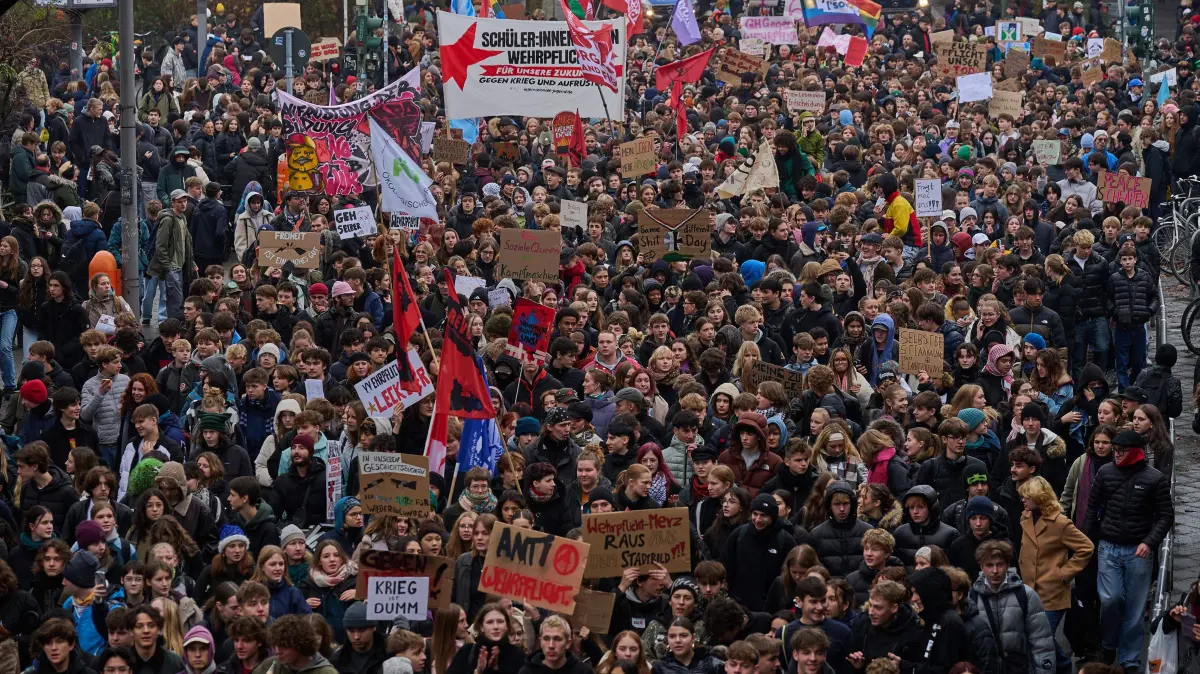 Jugendliche protestieren in Dutzenden Staedten gegen Wehrdienst: Schuelerinnen und Schueler haben bei Demos gegen den kuenftigen Wehrdienst ihrer Wut und ihrem Frust Luft gemacht. In fast 90 Staedten und Regionen waren Proteste geplant - teilweise waehrend der Unterrichtszeit (hier im Foto vom 05.12.2025 eine Demonstration in Berlin Kreuzberg). Der Bundestag hat am Freitag ein Wehrdienst-Gesetz beschlossen. Es sieht ab 2026 eine Musterungspflicht fuer junge Maenner von 18 Jahren und das verpflichtende Ausfuellen eines Fragebogens vor. Der Dienst selbst bleibt freiwillig. (Siehe epd-Meldungen vom 05.12.2025)