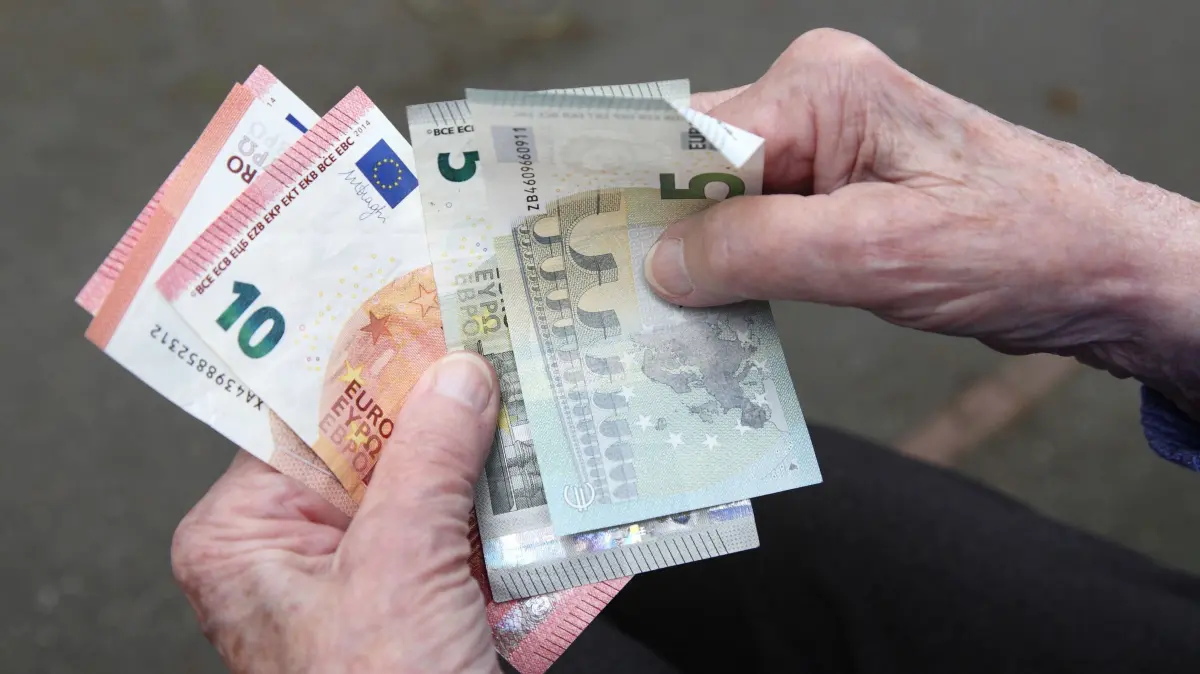 Rentenpaket geht mit Kanzlermehrheit durch den Bundestag: Eine Seniorin haelt Geldscheine in ihrer Hand (Themenfoto). Die Koalition aus Union und SPD kann aufatmen: Ihr Rentenpaket ist am Freitag (05.12.2025) mit absoluter Mehrheit vom Bundestag beschlossen worden. (Siehe epd-Meldung vom 05.12.2025)