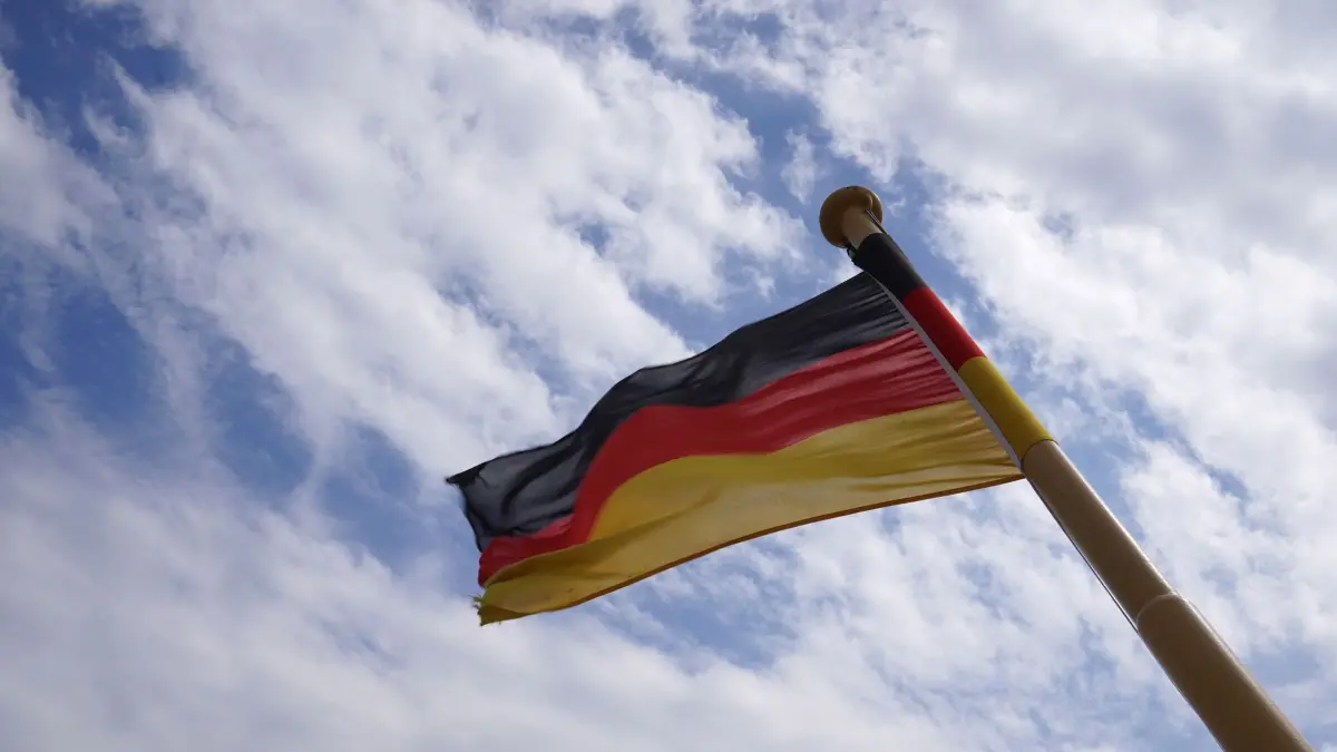 Deutschland-Flagge: ARCHIV - 10.05.2021, Schleswig-Holstein, Nordstrand: Eine deutsche Flagge weht auf einer Fähre im Wind. (zu dpa: «Regierung plant Reform für Schiffsregister und Flaggenrecht») Foto: Marcus Brandt/dpa +++ dpa-Bildfunk +++