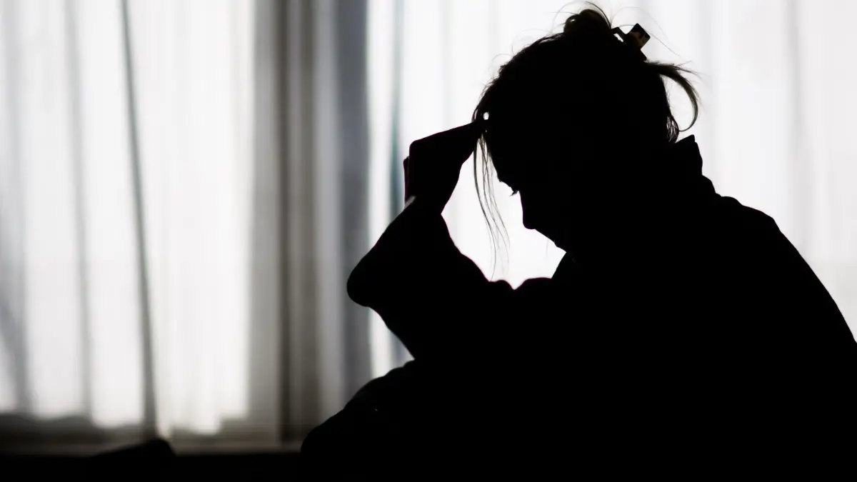 Einsamkeit und soziale Isolation: ARCHIV - 19.02.2025, Niedersachsen, Hannover: ILLUSTRATION - Die Silhouette einer Frau zeichnet sich vor einer hellen Fensterfront ab (gestellte Szene). (zu dpa: «Wann wird Einsamkeit zum Problem?») Foto: Julian Stratenschulte/dpa +++ dpa-Bildfunk +++
