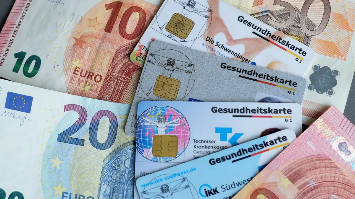 Zusatzbeitraege der Krankenkassen: Gesundheitskarten verschiedener Krankenkassen auf Euro-Banknoten (Themenfoto). Viele gesetzliche Krankenversicherungen (GKV) erhoehen im kommenden Jahr ihre Zusatzbeitraege. Laut dem GKV-Schaetzerkreis wird der Zusatzbeitrag im Schnitt um 0,4 Prozentpunkte steigen auf dann 2,9 Prozent des Bruttolohns. Fuer 2025 hatte das Gesundheitsministerium einen Durchschnittswert von 2,5 Prozent festgelegt.
(Siehe epd-Meldung vom 30.12.2025) *** Local Caption *** 00359361