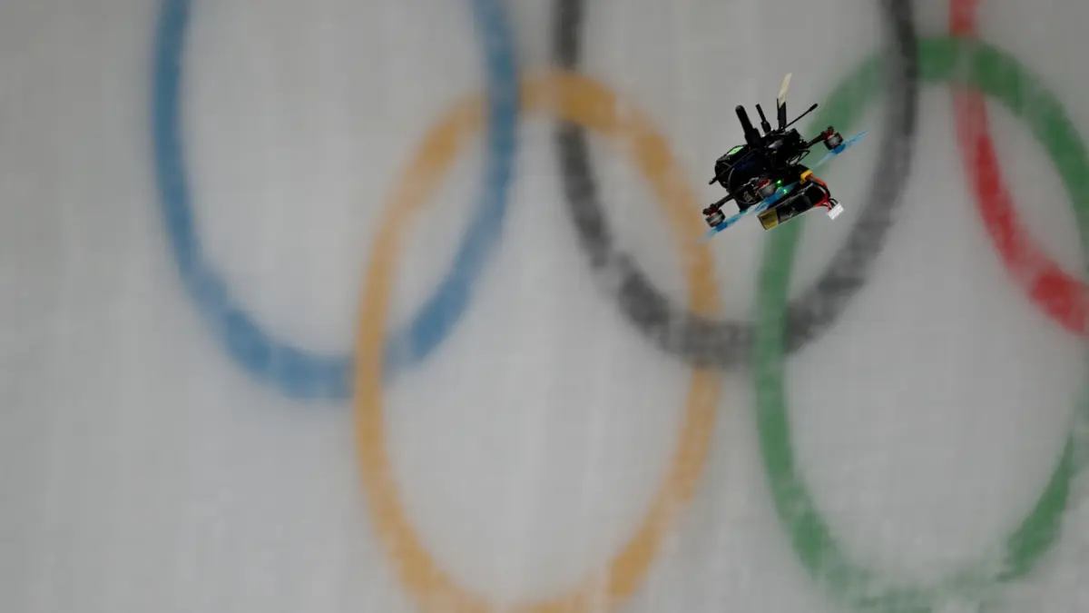 Olympische Winterspiele 2026: 09.02.2026, Italien, Cortina Džampezzo: Olympia, Olympische Winterspiele Mailand Cortina 2026, Rodeln, Vorkampf, Einsitzer, Frauen, Durchgang 1 eine Drohne fliegt über den Eiskanal mit den olympischen Ringen. Foto: Robert Michael/dpa +++ dpa-Bildfunk +++