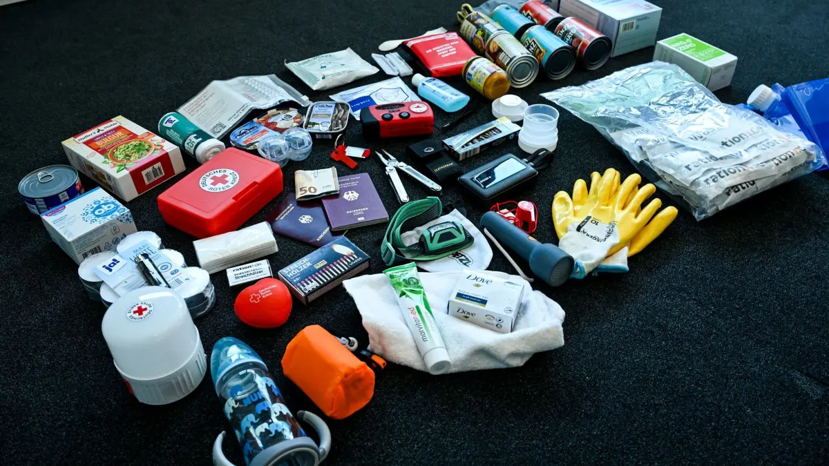 Notfallpaket: PRODUKTION - 17.04.2025, Berlin: Ein Notfallpaket aus der Krisenvorsorge mit typischen Bestandteilen wie Radio, Taschenlampe, Konserven, Erste-Hilfe-Set, Streichhölzern, Feuerzeug, Hygieneartikeln, Handschuhen, Akkus und Batterien liegt beim Deutschen Roten Kreuz DRK. (zu dpa: «Hilfsorganisationen fordern mehr Selbstschutz bei Krisen») Foto: Jens Kalaene/dpa +++ dpa-Bildfunk +++