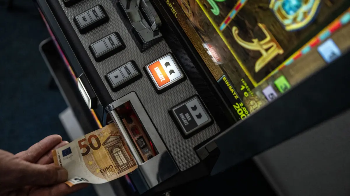 Illegales Glücksspiel: ARCHIV - 04.02.2022, Nordrhein-Westfalen, Unna: ILLUSTRATION - Ein Geldschein wird in einen Fun-Game-Automat geschoben. (zu dpa: «Durchsuchungen in Görlitz - Spielautomaten sichergestellt») Foto: Bernd Thissen/dpa +++ dpa-Bildfunk +++