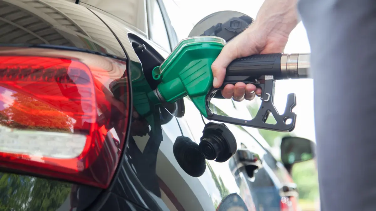 Mann betankt sein Auto: ILLUSTRATION - Umweltaspekt im Fokus: Der Bioethanol-Anteil in E10 soll den CO₂-Ausstoß im Vergleich zu reinem Benzin reduzieren, und ist in der Regel günstiger als das höherwertige Super Plus. (zu dpa: «Sparoption an der Tankstelle: Viele Benziner vertragen E10») Foto: Christin Klose/dpa-tmn - Honorarfrei nur für Bezieher des dpa-Themendienstes +++ dpa-Themendienst +++