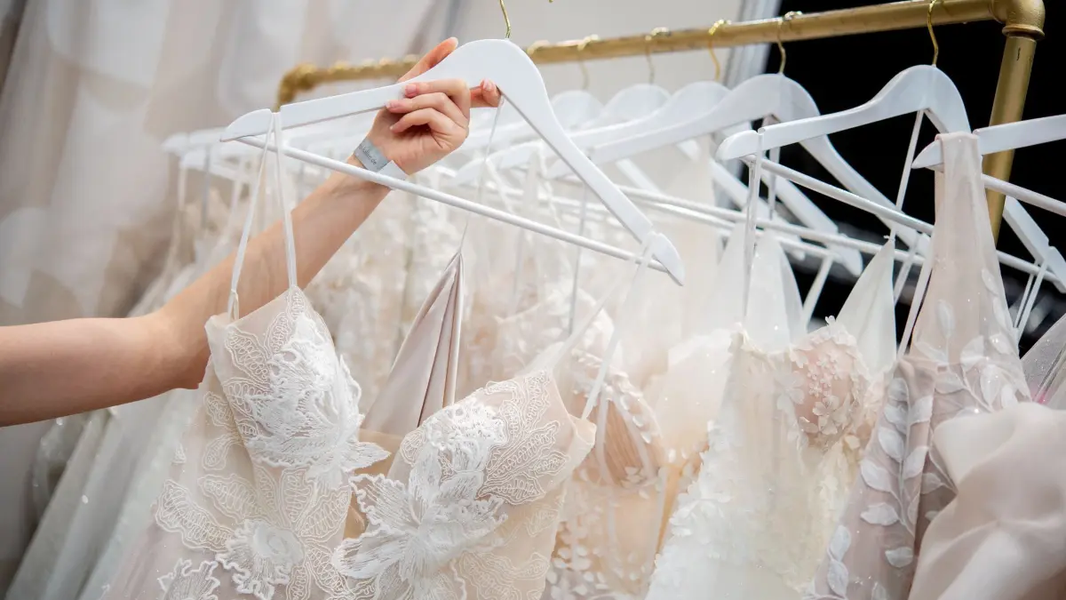 Frau betrachtet ein Hochzeitskleid: ARCHIV - Wer ein Brautkleid sucht, hat die Qual der Wahl - auch bei der Frage: Online kaufen oder im stationären Handel? (zu dpa: «Geht das? Stilvoll sparen bei der Hochzeitskleidung») Foto: Hauke-Christian Dittrich/dpa/dpa-mag - Honorarfrei nur für Bezieher des Dienstes dpa-Magazin +++ dpa-Magazin +++