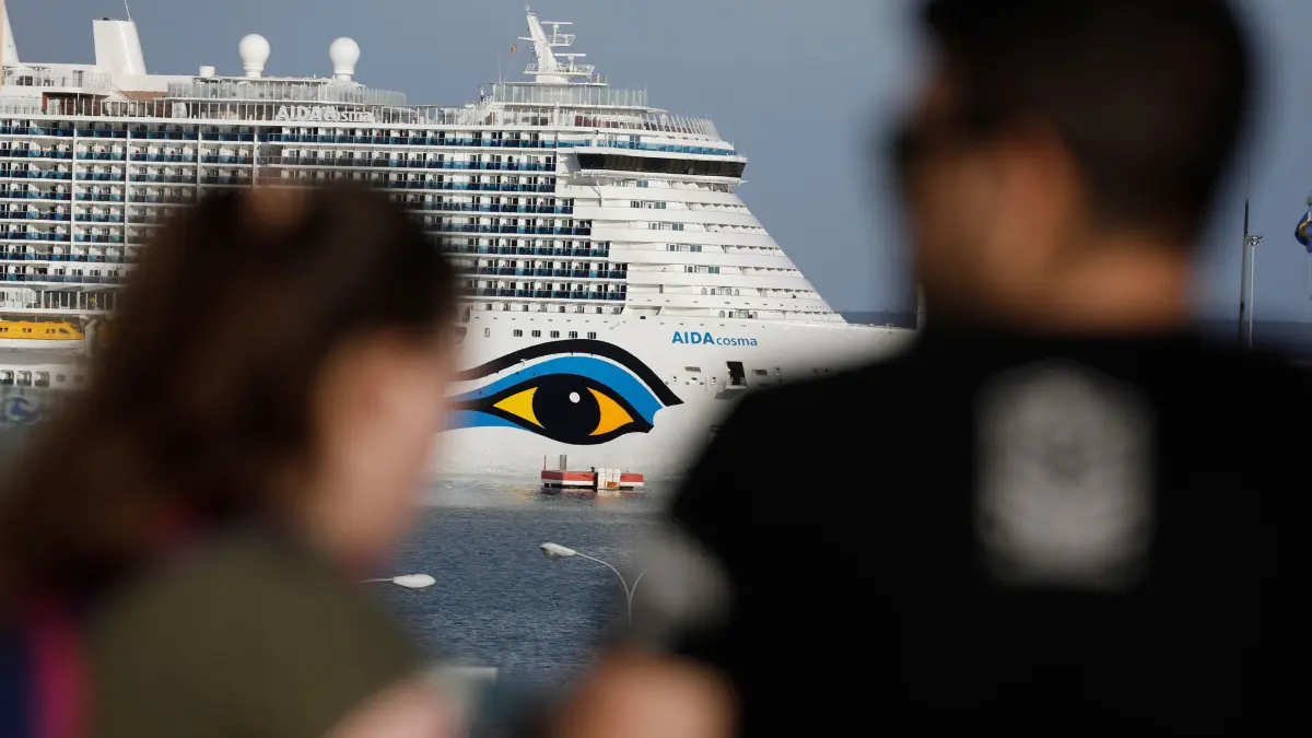 Kreuzfahrtschiffe vor Mallorca: ARCHIV - 07.05.2022, Spanien, Palma: Menschen schauen nach dem Kreuzfahrtschiff Aidacosma, das im Hafen von Palma auf Mallorca angelegt hat. Palma begrenzt die Anzahl der Kreuzfahrtschiffe: Es dürfen nur drei gleichzeitig an einem Tag anlegen und nur eines von ihnen darf mehr als 5000 Passagiere aufnehmen. (zu dpa: «Von Erfurt aus zur Kreuzfahrt - Neuer Sommerflugplan») Foto: Clara Margais/dpa +++ dpa-Bildfunk +++