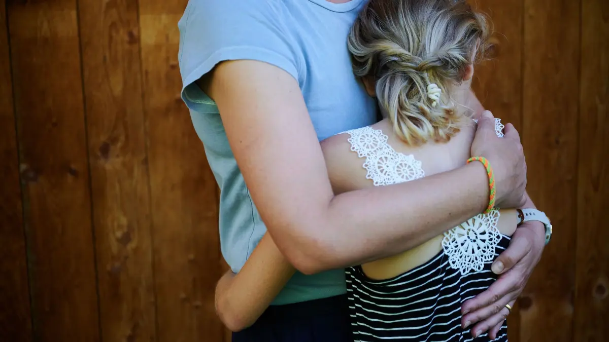 Ein Mädchen wird von seiner Mutter in den Arm genommen: ILLUSTRATION - Laut Experten völlig normal: Dass es in einer Patchworkfamilie auch mal knirscht. (zu dpa: «Wie neue Partner ihre Rolle im Patchwork finden - 5 Tipps») Foto: Annette Riedl/dpa/dpa-tmn - Honorarfrei nur für Bezieher des dpa-Themendienstes +++ dpa-Themendienst +++