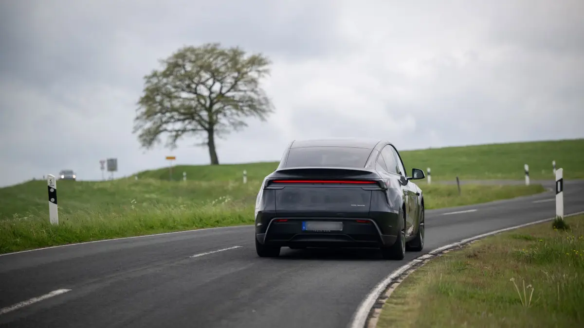 Pilotprojekt mit selbstfahrenden Teslas in der Eifel: 11.05.2026, Rheinland-Pfalz, Gerolstein: Ein selbstfahrender Tesla Modell Y ist autonom auf den Straßen der Eifel unterwegs. Ein am Steuer sitzender Werksfahrer greift bei Bedarf in das Software-Update «Full Self-Driving» (FSD/Überwacht) ein, das bundesweit noch nicht zugelassen ist. (zu dpa: «Selbstfahrende Teslas bringen Schüler und Senioren ans Ziel») Foto: Harald Tittel/dpa +++ dpa-Bildfunk +++