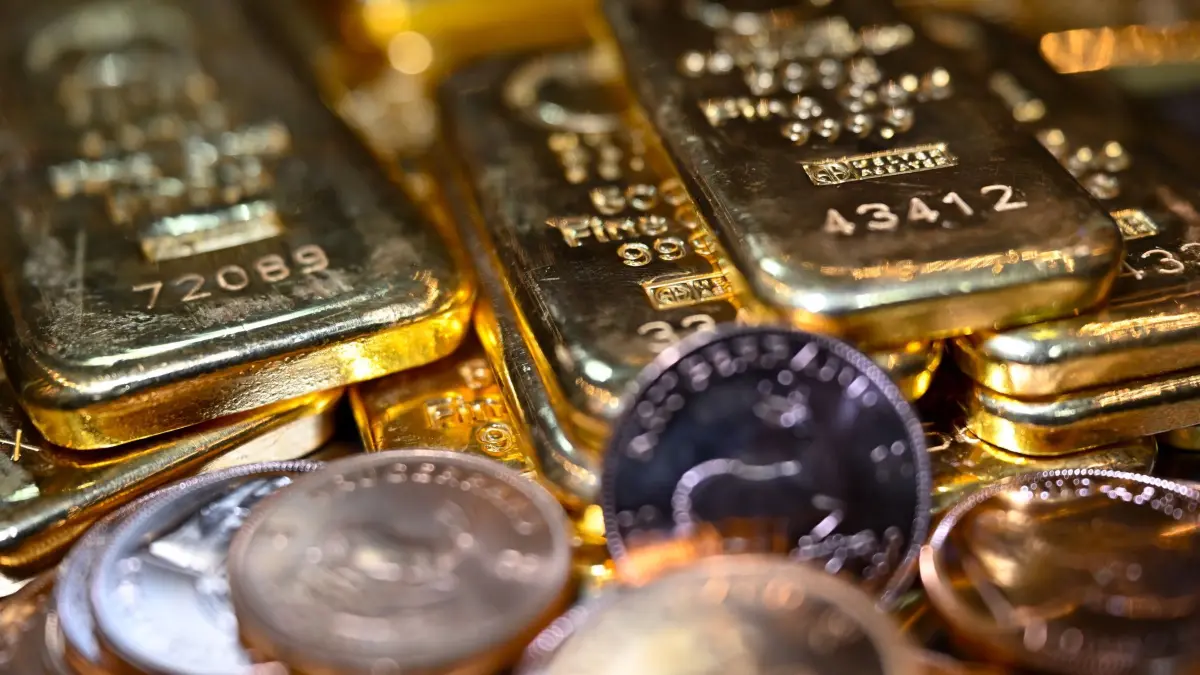 Gold: ARCHIV - 02.02.2026, Bayern, München: Goldbarren und Münzen (Krügerrand) liegen beim Edelmetallhändler Pro Aurum in einem Tresor auf einem Tisch. (zu dpa: «Betrüger ergaunern Goldmünzen im Wert von 300.000 Euro») Foto: Sven Hoppe/dpa +++ dpa-Bildfunk +++