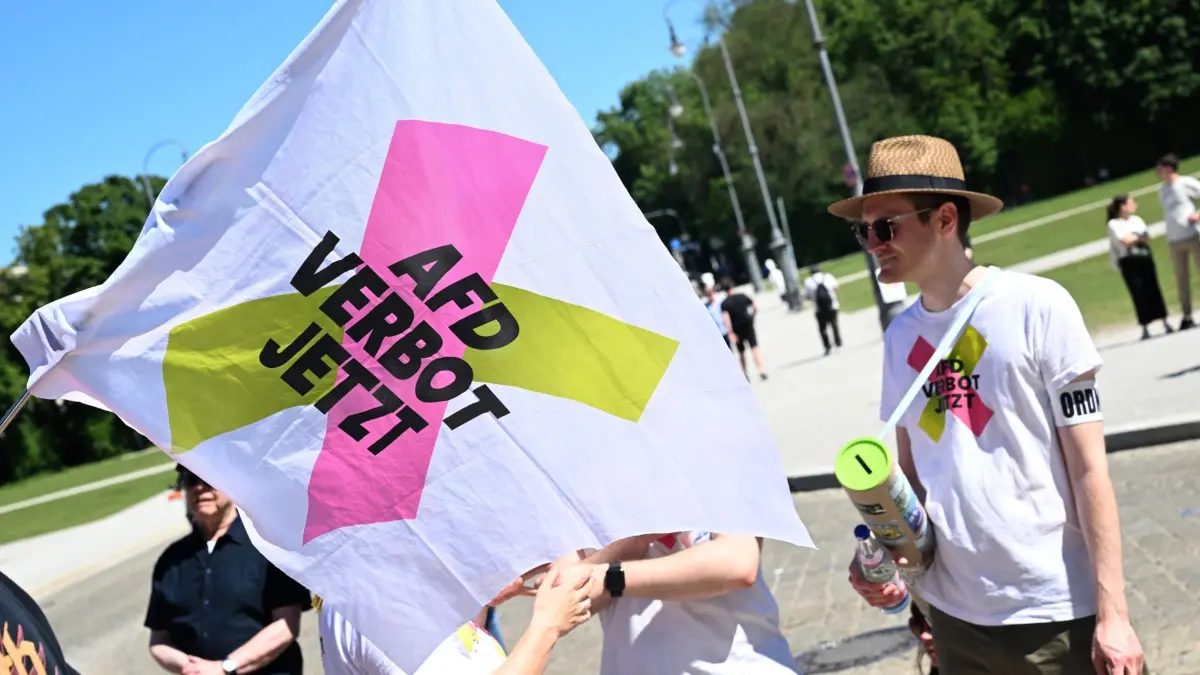 Aktionstag „Menschenwürde verteidigen - AfD-Verbot jetzt!“: 23.05.2026, Bayern, München: Demonstranten stehen mit einer Fahne «AFD Verbot jetzt» beim bundesweiten Aktionstag «Menschenwürde verteidigen - AfD-Verbot jetzt!» auf dem Königsplatz. Foto: Felix Hörhager/dpa +++ dpa-Bildfunk +++