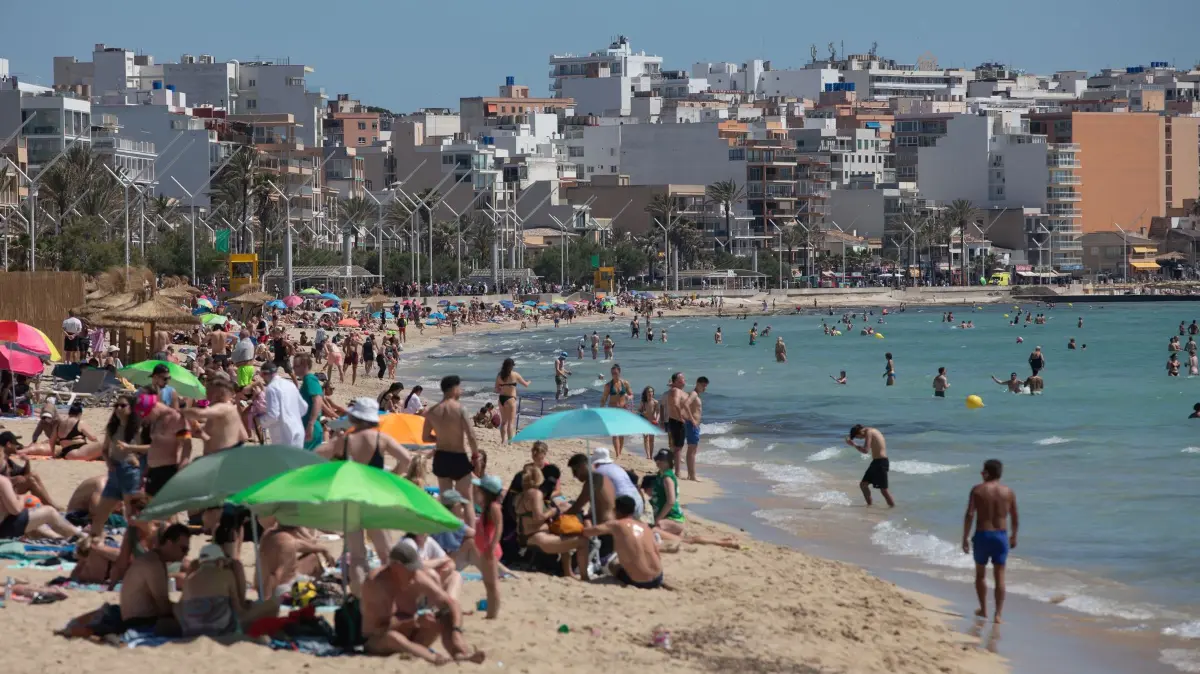 Wetter auf Mallorca: 24.05.2026, Spanien, Palma: Menschen sonnen sich und schwimmen am Strand Playa de Palma auf Mallorca. Temperaturen von über 30 Grad haben Einheimische und Besucher an die Küste gelockt, um das Wetter zu genießen. Foto: Clara Margais/dpa +++ dpa-Bildfunk +++