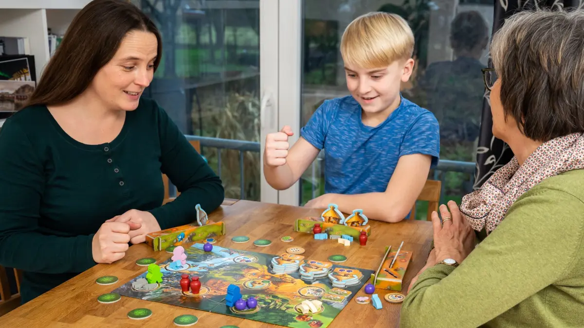 Familie spielt gemeinsam ein Brettspiel: ILLUSTRATION - Gemeinsame Spieleabende werden von Gesundheitsexperten als Alternative zur Bildschirmzeit genannt. (zu dpa: «Was ohne Medien: 8 Ideen für bildschirmfreie Familienzeit») Foto: Benjamin Nolte/dpa-tmn - Honorarfrei nur für Bezieher des dpa-Themendienstes +++ dpa-Themendienst +++