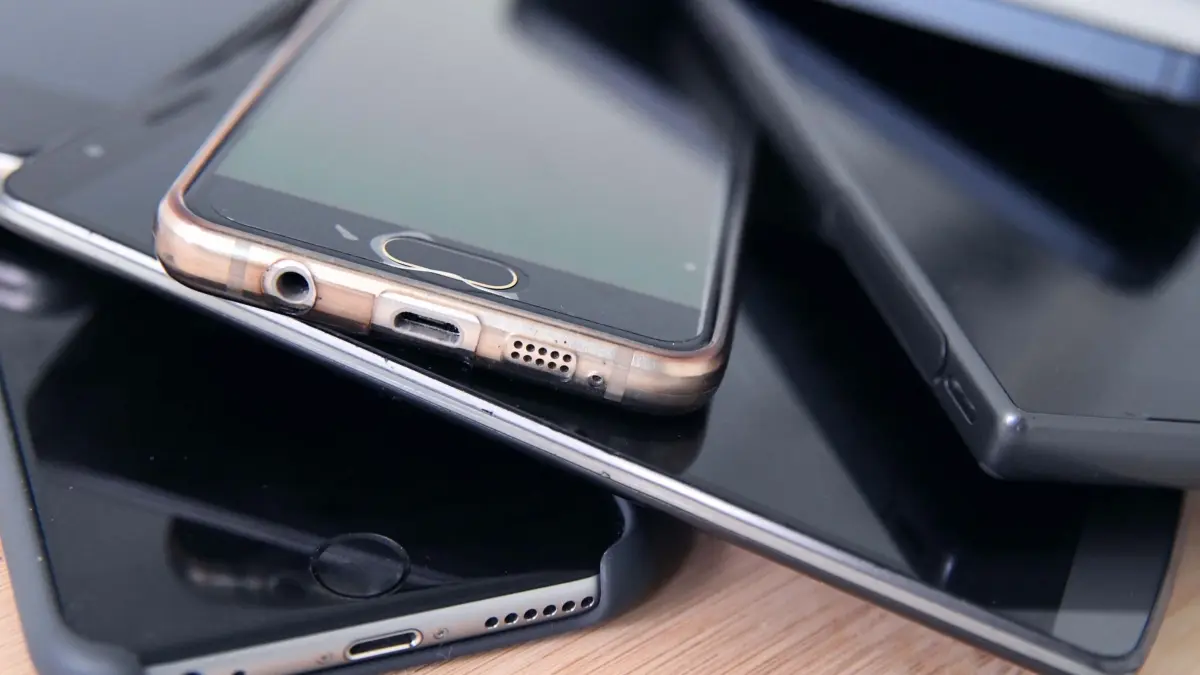 Alte Smartphones liegen aufeinander gestapelt: ILLUSTRATION - Recycling statt Schublade: Alte Smartphones und Akkus gehören nicht in den Hausmüll, sondern sollten fachgerecht entsorgt werden. Foto: Karolin Krämer/dpa-mag - Honorarfrei nur für Bezieher des Dienstes dpa-Magazin +++ dpa-Magazin +++