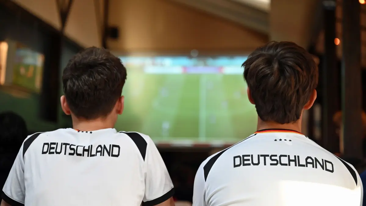 WM - Deutschland gegen Japan: ARCHIV - 10.11.2022, Berlin: Zwei junge Männer sehen sich das WM-Spiel Deutschland gegen Japan in einer Kneipe an. (zu dpa: «Fußball-WM: Gastronomen hoffen auf Umsatz trotz Hürden») Foto: Lena Lachnit/dpa +++ dpa-Bildfunk +++