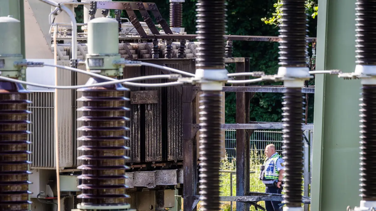 Großflächiger Stromausfall in Reutlingen: 08.06.2026, Baden-Württemberg, Reutlingen: Ein Polizist steht im Rahmen der Ermittlungen im Umspannwerk. Nach einem großflächigen Stromausfall in Reutlingen stehen Polizeikräfte auf dem Gelände eines Umspannwerks, in dem es in der Nacht gebrannt hatte. Foto: Christoph Schmidt/dpa +++ dpa-Bildfunk +++