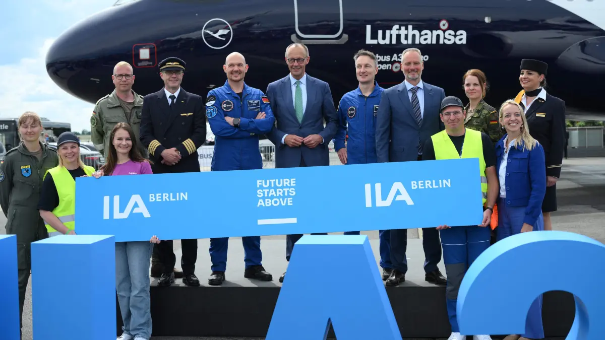 German Chancellor Friedrich Merz (C) poses with Alexander Gerst (C-L)and Matthias Maurer (C-R), astronauts of the European Space Agency (ESA) and Airbus and Lufthansa staff members during the opening day of International Aerospace Exhibition (ILA) in Schoenefeld, near Berlin on June 10, 2026. (Photo by RALF HIRSCHBERGER / AFP)
