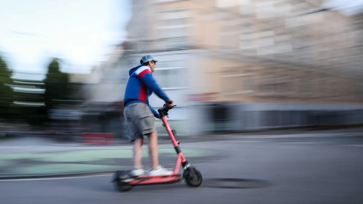 Ein Mann ist auf einem E-Scooter in Hamburg unterwegs (Aufnahme mit langer Verschlusszeit). Die Bundesregierung plant neue Regeln zu E-Scootern. (zu dpa: «Mediziner wegen mehr Unfällen mit E-Scootern «alarmiert»») +++ dpa-Bildfunk +++
