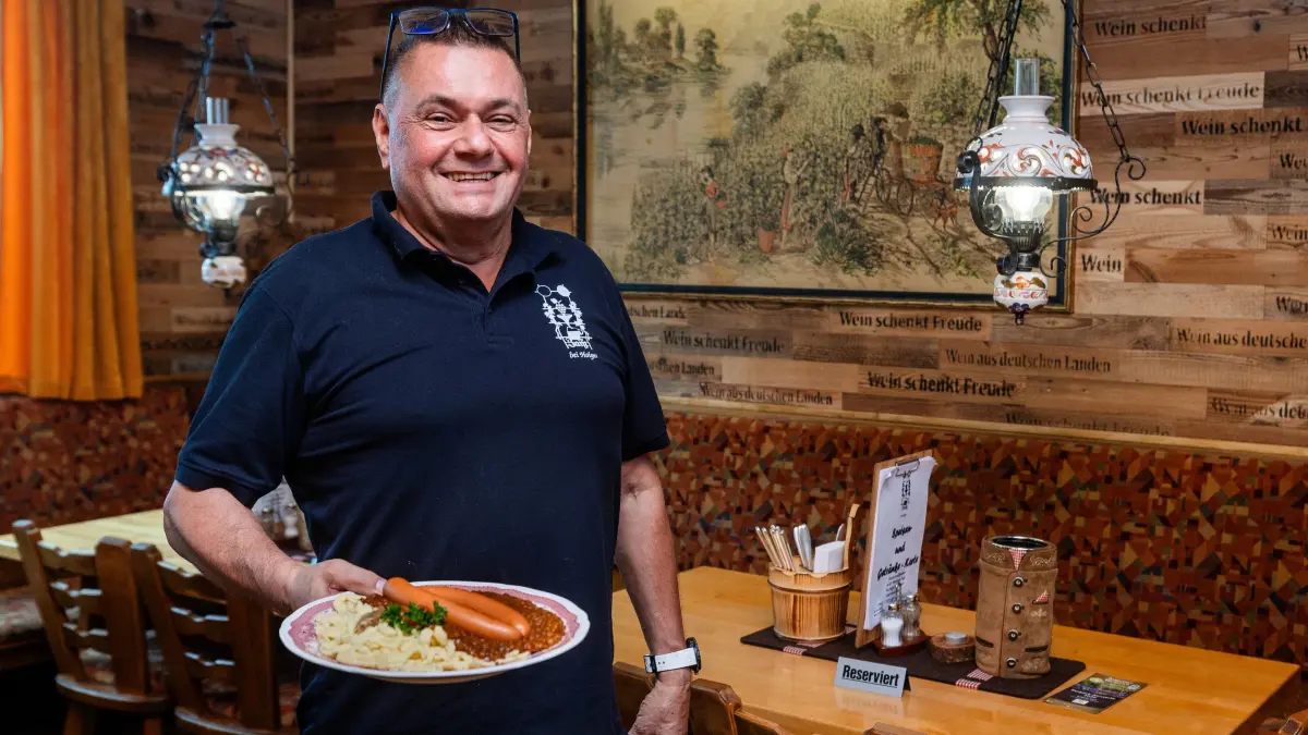 Weinstube Zaiß: 12.06.2026, Stuttgart: Holger Waiblinger, Chef der Weinstube Zeiß in Bad Cannstatt mit einem Teller Linsen mit Spätzle in der Hand. Foto: Lichtgut/Christoph Schmidt