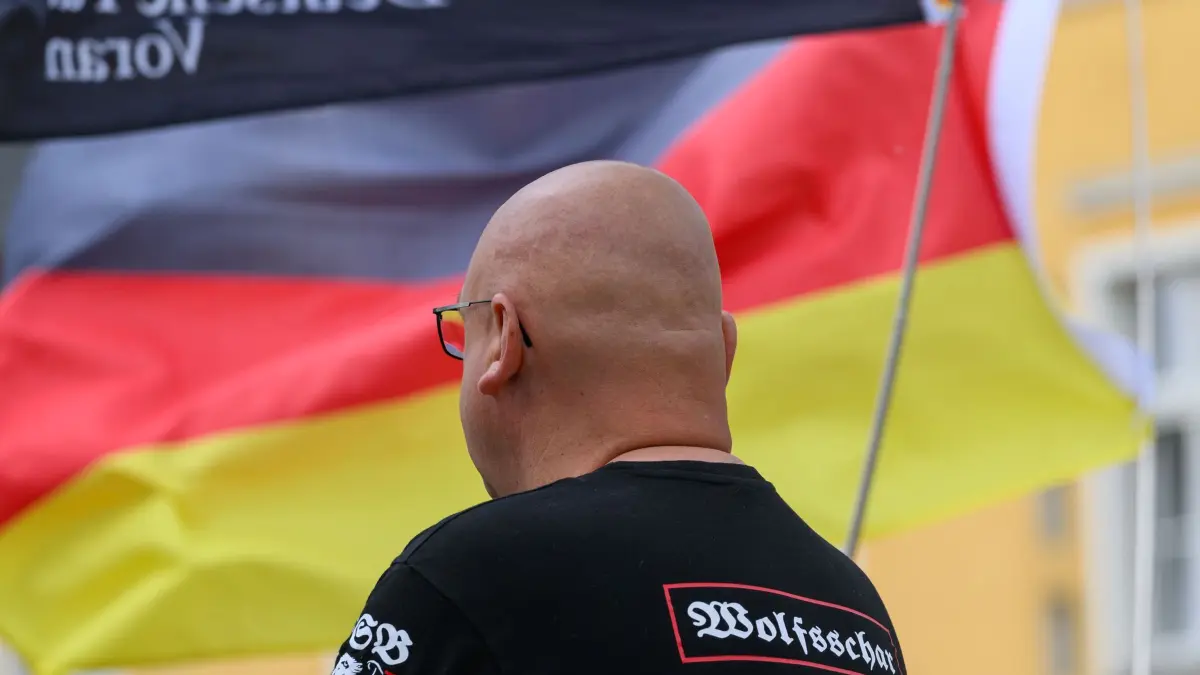 CSD in Eberswalde wird begleitet von rechtem Protest: 13.06.2026, Brandenburg, Eberswalde: Ein Teilnehmer der Gruppierung «Deutsche Patrioten voran» nimmt an einer Gegenversammlung zum Christopher Street Day teil. Etwa 1.000 Menschen haben beim Christopher Street Day in Eberswalde begleitet von einer Gegendemo aus der rechtsextremen Szene für Toleranz geworben. Unter dem Motto «Viele Farben - ein Wir» zogen sie vom Bahnhof zum Zentrum der Stadt nordöstlich von Berlin unter erhöhtem Polizeischutz. Die Veranstalter sprachen von rund 1.100 Besucherinnen und Besuchern, die Polizei ging von einer hohen dreistelligen Zahl aus. Am Protestzug nahmen nach Angaben eines Polizeisprechers etwa 50 Teilnehmer teil. Der CSD und die Gegenversammlung verliefen bisher friedlich. Foto: Patrick Pleul/dpa +++ dpa-Bildfunk +++