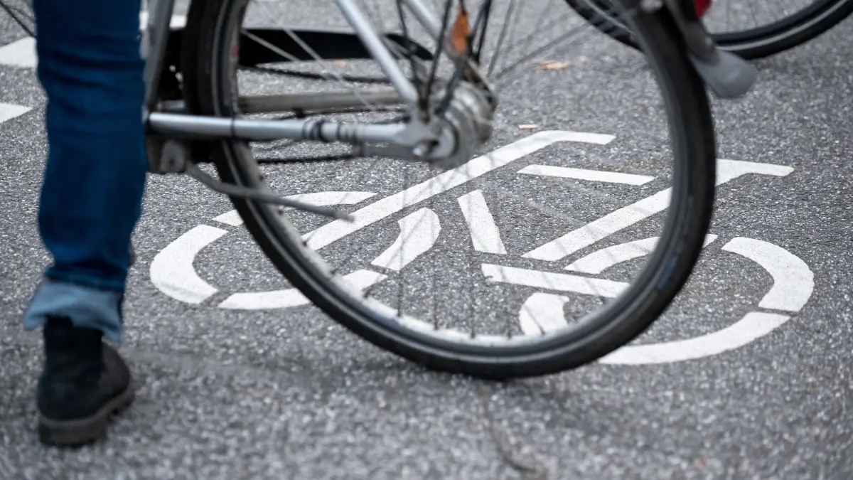 Fahrradfahrer (Symbolbild): ARCHIV - 31.10.2021, Hamburg: Ein Fahrrad-Symbol ist auf der Fahrbahn einer Straße hinter einem Fahrrad zu sehen. (zu dpa: «Radfahrer stürzt und verletzt sich schwer») Foto: Jonas Walzberg/dpa +++ dpa-Bildfunk +++