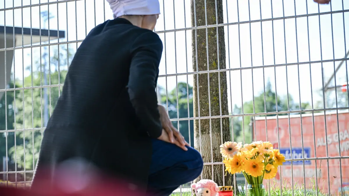 Nach dem Fund von leblosem Kind in Auto: 18.06.2026, Baden-Württemberg, Schorndorf: Eine Frau legt Blumen nieder, nachdem ein lebloses Kind in einem Auto gefunden wurde. Foto: Jason Tschepljakow/dpa +++ dpa-Bildfunk +++