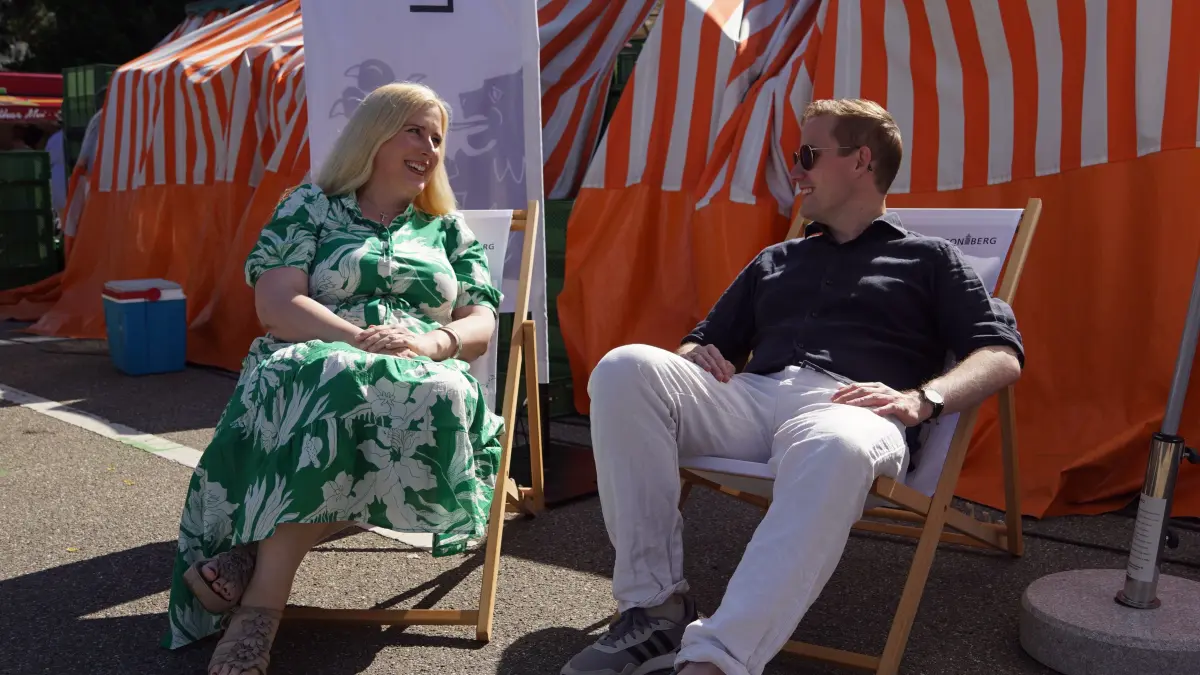 Josefa von Hohenzollern, Erste Bürgermeisterin, und Tobias Degode, Oberbürgermeister Leonberg, entspannt in Liegestühlen auf Wochenmarkt am Festplatz Steinstraße