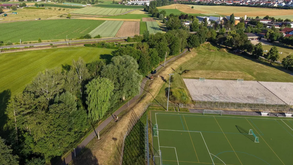 Nach dem Fund eines toten Säuglings in Renningen: 20.06.2026, Baden-Württemberg, Renningen: Ein Weg führt entlang eines Bachlaufs, wo die Leiche eines Babys entdeckt wurde (Aufnahme mit Drohne). Mit Dutzenden Suchhunden und Hubschraubern suchte die Polizei seit dem Vortag nach einem Säugling. Foto: Marius Bulling/dpa +++ dpa-Bildfunk +++