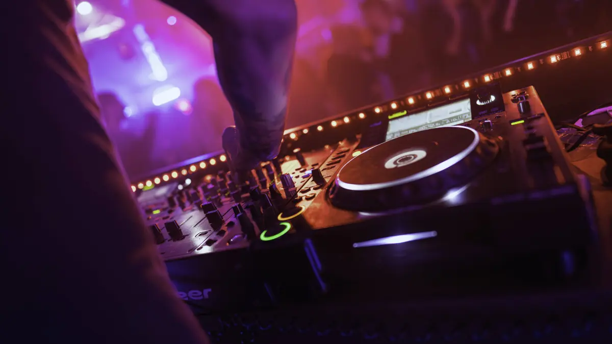 Rovigo, italy 18 december 2025: dj hand adjusting mixer controls, shaping electronic beats and bass in neon-lit club crowd for high-energy nightlife performance Dj mixing music on turntable at nightclub party Copyright: xx road 134