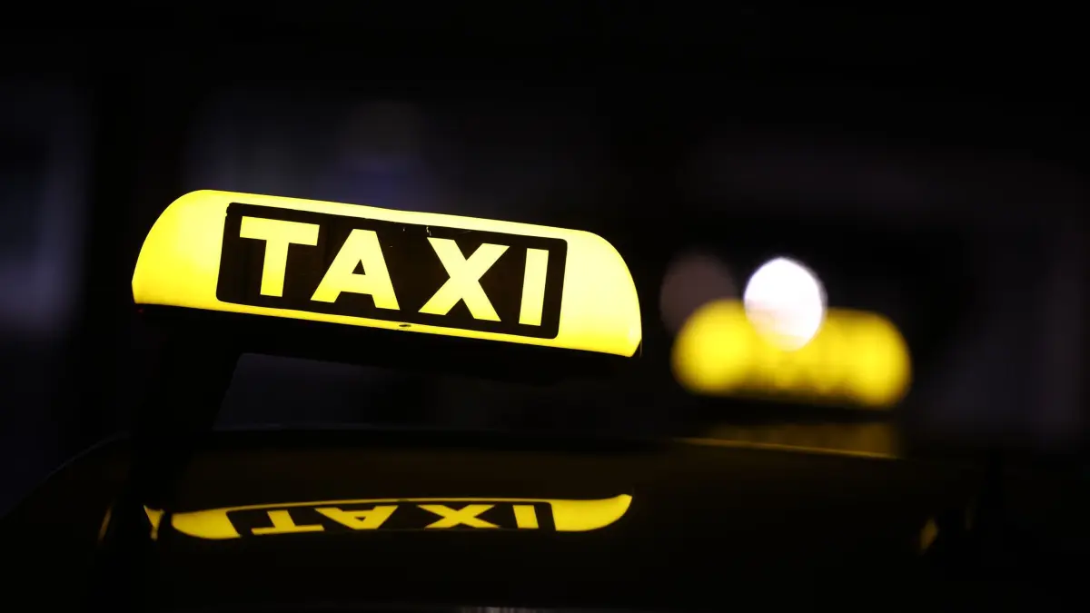 Bahnverkehr wegen Funkstörung bundesweit eingestellt: 23.06.2026, Nordrhein-Westfalen, Duisburg: Ein Taxi-Leuchtschilder ist auf einem Auto vor dem Hauptbahnhof Duisburg zu sehen. Der Verkehr der Deutschen Bahn ist wegen einer Funkstörung bundesweit eingestellt. Foto: Christoph Reichwein/dpa +++ dpa-Bildfunk +++