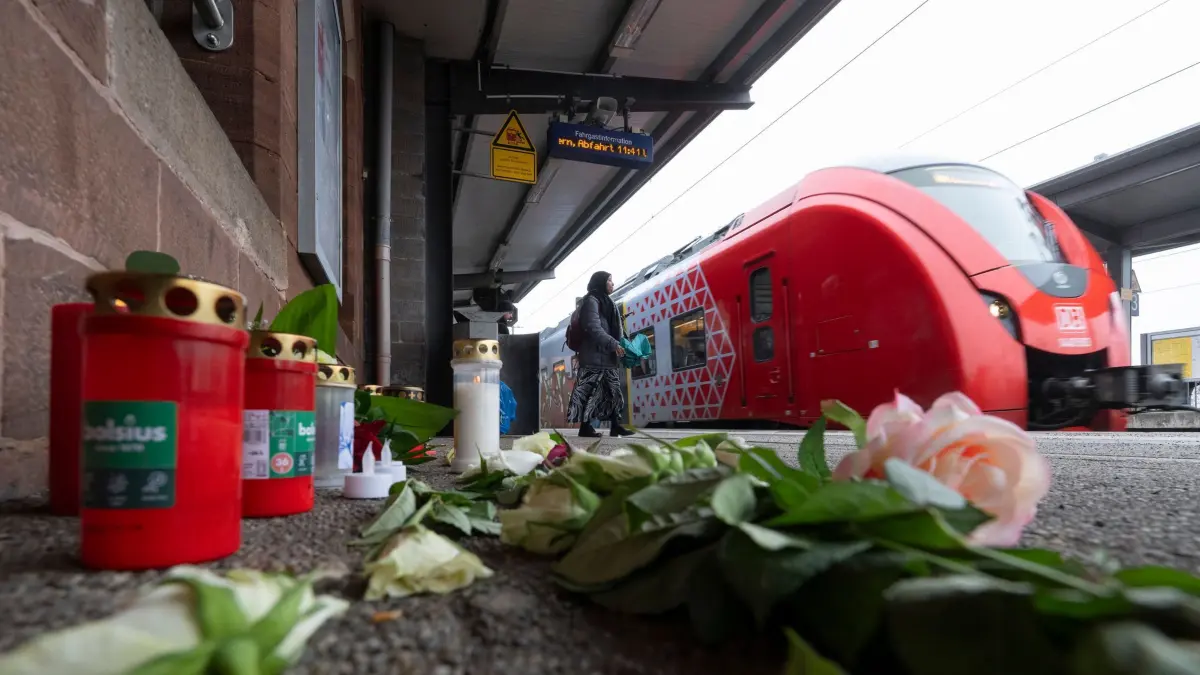 Nach Tod eines Zugbegleiters - Bahnhof Landstuhl: ARCHIV - 06.02.2026, Rheinland-Pfalz, Landstuhl: Kerzen und Blumen erinnern auf dem Bahnsteig am Bahnhof in Landstuhl an den getöteten Bahnmitarbeiter Serkan C. (zu dpa: «Prozess um getöteten Zugbegleiter beginnt») Foto: Boris Roessler/dpa +++ dpa-Bildfunk +++