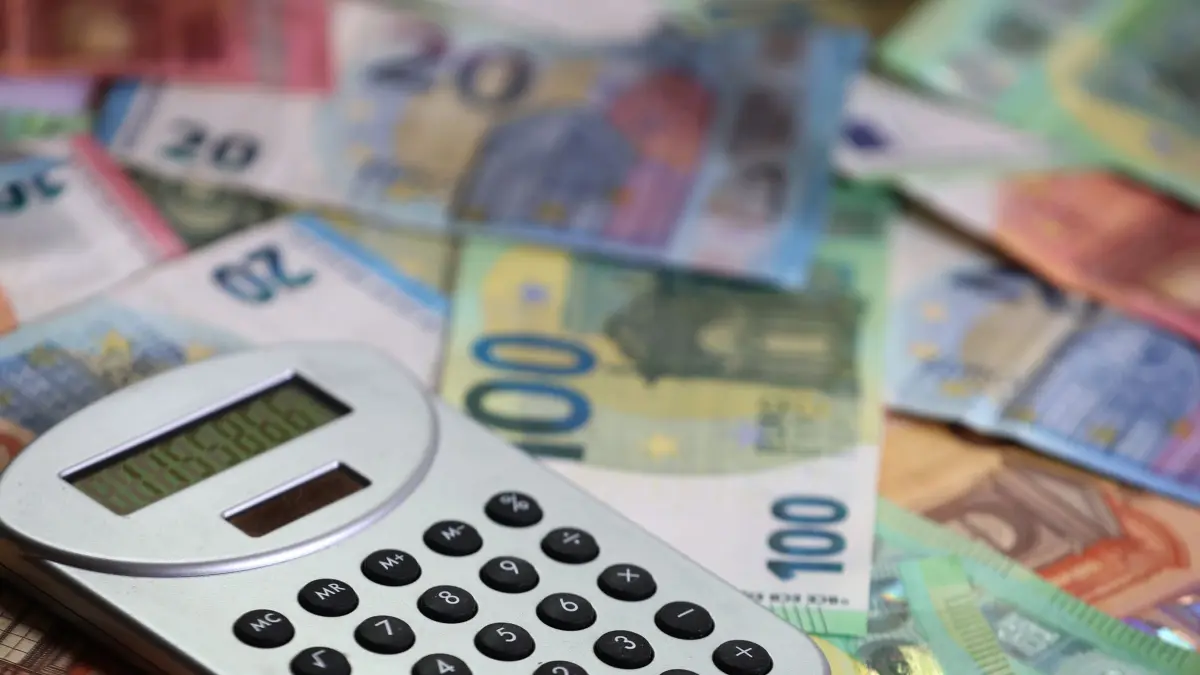 Kommunale Haushalte: ILLUSTRATION - 15.05.2024, Bayern, Kaufbeuren: ILLUSTRATION Ein Taschenrechner liegt auf verschiedenen Euro-Banknoten. Klamme Kommunen sollen schneller Geld bekommen. (zu dpa: «Kaufkraft im Hoch: Die Inflationsdelle ist ausgeglichen») Foto: Karl-Josef Hildenbrand/dpa +++ dpa-Bildfunk +++