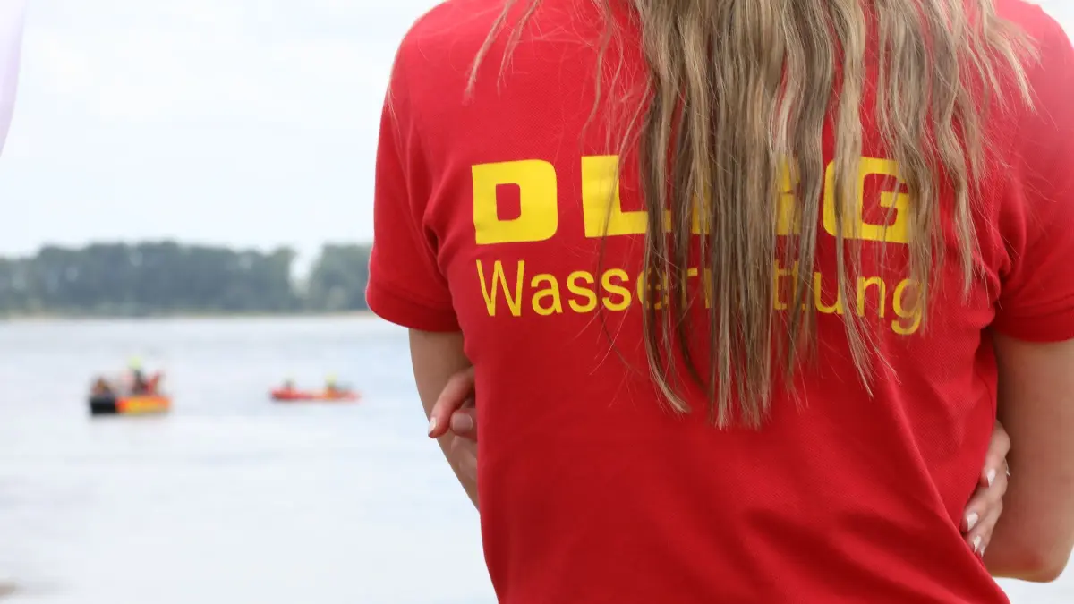 DLRG warnt vor spezieller Blaualgenart in einem Badesee: ARCHIV - 08.08.2024, Nordrhein-Westfalen, Düsseldorf: Ein Mitglied der Deutschen-Lebens-Rettungs-Gesellschaft (DLRG) beobachtet eine Rettungsübung auf dem Rhein. (zu dpa: «Blaualgen in See entdeckt - Was die DLRG den Menschen rät») Foto: Sascha Thelen/dpa +++ dpa-Bildfunk +++