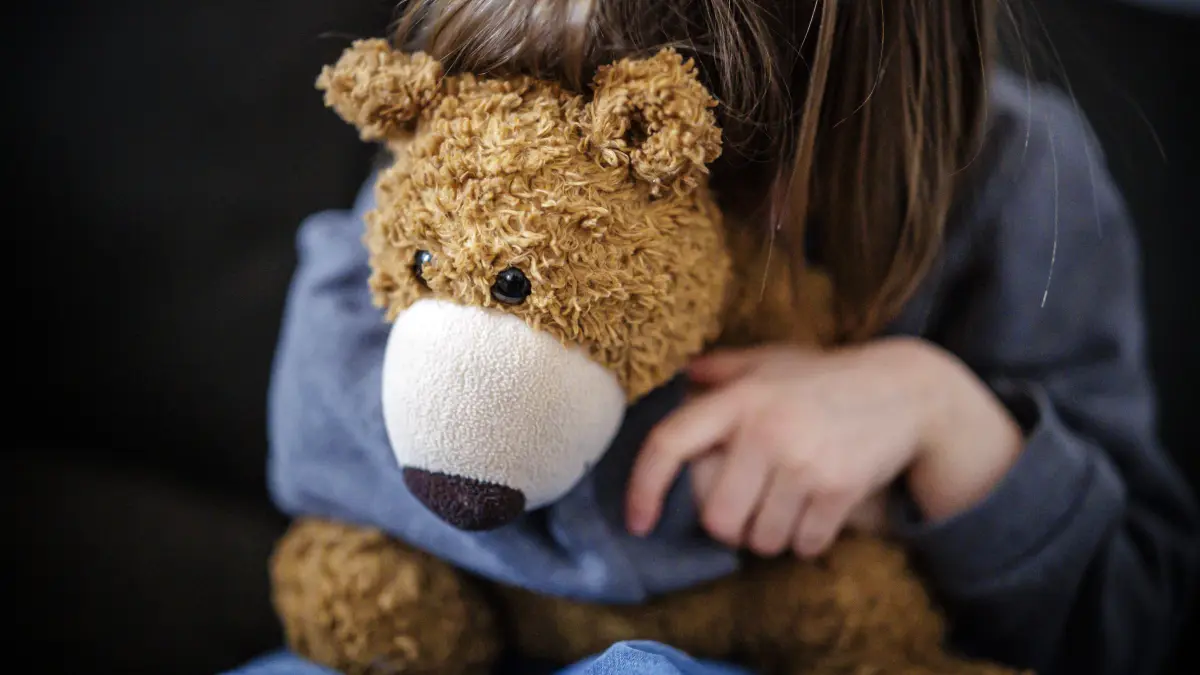 Symbolfoto zum Thema Angst bei Kindern. Gestellte Aufnahme. Ein kleines Maedchen versteckt sich traurig hinter einem Kuscheltier. Berlin, 16.02.2026. Berlin Deutschland *** Symbolic photo on the subject of fear in children Staged photo A little girl hides sadly behind a cuddly toy Berlin, 16 02 2026 Berlin Germany Copyright: xThomasxTrutschelx