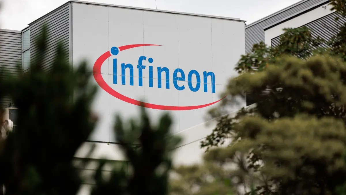 FILES-GERMANY-ECONOMY-TECHNOLOGY-IT-SCIENCE-SEMICONDUCTORS-INFIN: (FILES) The logo of German semiconductor manufacturer Infineon Technologies AG is seen at the company's plant in Dresden, eastern Germany, on June 10, 2026. On July 2, 2026, Infineon will officially open its Smart Power Fab that manufactures power semiconductors as well as analog/mixed-signal-components in Dresden. With an investment of five billion euros, the new facility represents the largest single investment in Infineon's history. (Photo by Jens SCHLÜTER / AFP)