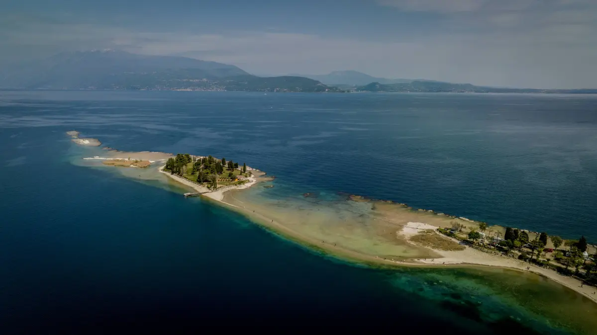 Drohnenaufnahme der Insel San Biagio am 28. April 2023. Der Pegelstand des Gardasees war damals wie bereits ein Jahr zuvor aufgrund lange anhaltender Trockenheit deutlich abgesunken.
