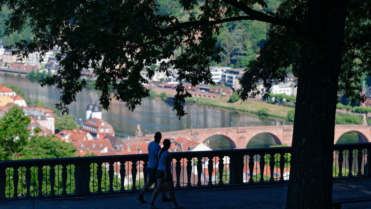 Wetter in Baden-Württemberg: 02.07.2026, Baden-Württemberg, Heidelberg: Besucher des Heidelberger Schlossparks gehen über einen Weg. Foto: Uwe Anspach/dpa +++ dpa-Bildfunk +++