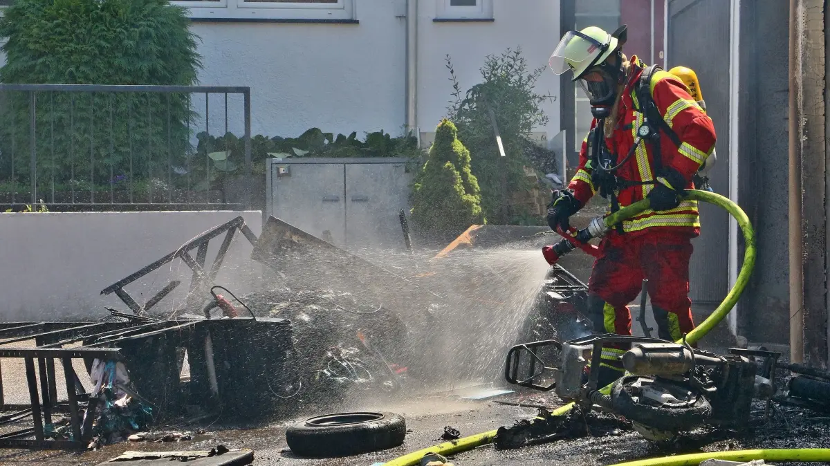 02.07.2026: Während am Donnerstagmittag bereits eine Vielzahl von Einsatzkräften der Leonberger Feuerwehr bei einem Gefahrgutunfall auf der A8 im Einsatz waren, meldeten Anrufer gegen 14 Uhr den Brand mehrerer Garagen im Ortsteil Höfingen. Die ILS Böblingen alarmierte daraufhin die Abteilungen Leonberg-Innenstadt, Höfingen und Gebersheim. Eine weithin sichtbare Rauchwolke wies den anfahrenden Kräften den Weg. Beim Eintreffen brannte eine Garage in einer Garagenanlage in voller Ausdehnung. Umgehend wurden zwei Rohre zur Brandbekämpfung vorgenommen. Mit einer Wärmebildkamera wurde kontrolliert ob sich das Feuer in das Dach bzw. die angrenzenden Garagen durchgefressen hatte. Nachdem der Brand gelöscht war, wurde im Rahmen der Nachlöscharbeiten die Garage ausgeräumt und mit dem Hochleistungslüfter entraucht.
Foto: KS-Images.de/Andreas Rometsch