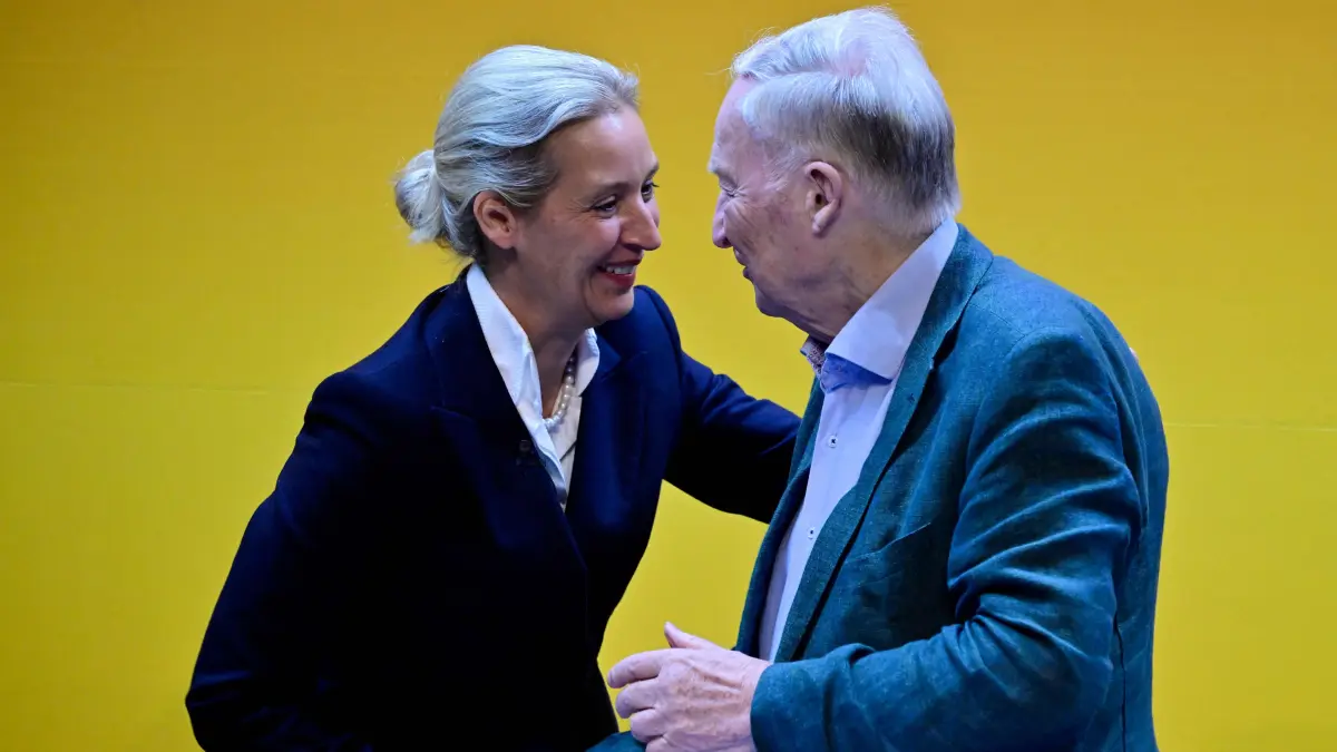 GERMANY-POLITICS-PARTIES-FAR RIGHT-AFD: AfD co-leader Alice Weidel (L) greets honorary chairman Alexander Gauland at the party congress of far-right Alternative for Germany (AfD) at the Messe Erfurt fairground in Erfurt, eastern Germany on July 4, 2026. Thousands of demonstrators flooded a German city on July 4, blocking major roads and disrupting public transport, in a bid to shut down the annual congress of the far-right AfD party. About 20,000 people flocked to Erfurt, in Thuringia state, according to police, to protest against the Alternative for Germany (AfD) party that tops national opinion polls. (Photo by John MACDOUGALL / AFP)