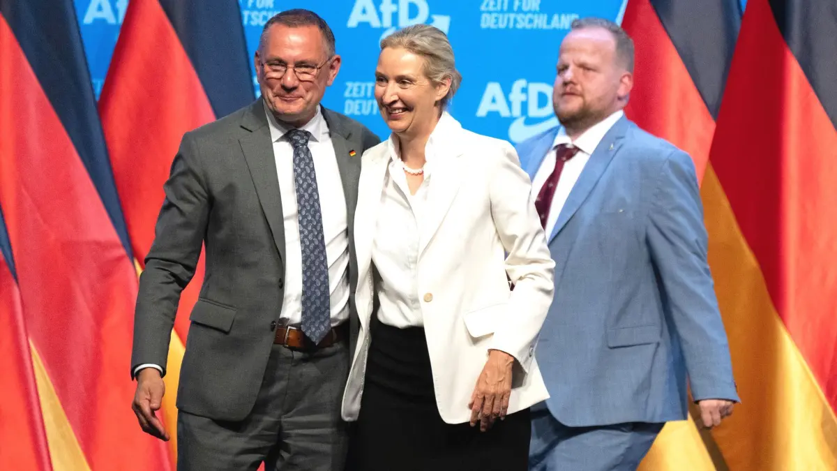 Bundesparteitag der AfD: 05.07.2026, Thüringen, Erfurt: Alice Weidel, AfD-Bundesvorsitzende, und Tino Chrupalla(l), AfD-Bundesvorsitzender und Fraktionsvorsitzender der AfD, stehen zum Abschluss des Bundesparteitags ihrer Partei in der Messe Erfurt auf der Bühne. Rechts steht Sven Tritschler (r,AfD), stellvertretender Bundesvorsitzender. Am 4. und 5. Juli findet der Bundesparteitag der AfD in der Messe Erfurt statt. Foto: Sebastian Kahnert/dpa +++ dpa-Bildfunk +++