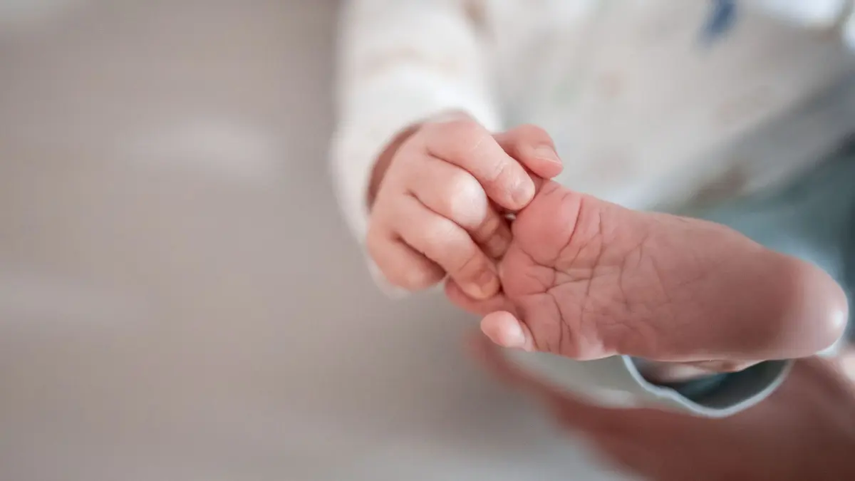 Elterngeld: ARCHIV - 30.12.2019, Nordrhein-Westfalen, Oberhausen: Ein Baby greift mit den Fingern nach seinem Fuß. (zu dpa: «Priens Plan: Elterngeld nur noch ein Jahr - dafür etwas mehr») Foto: Fabian Strauch/dpa +++ dpa-Bildfunk +++