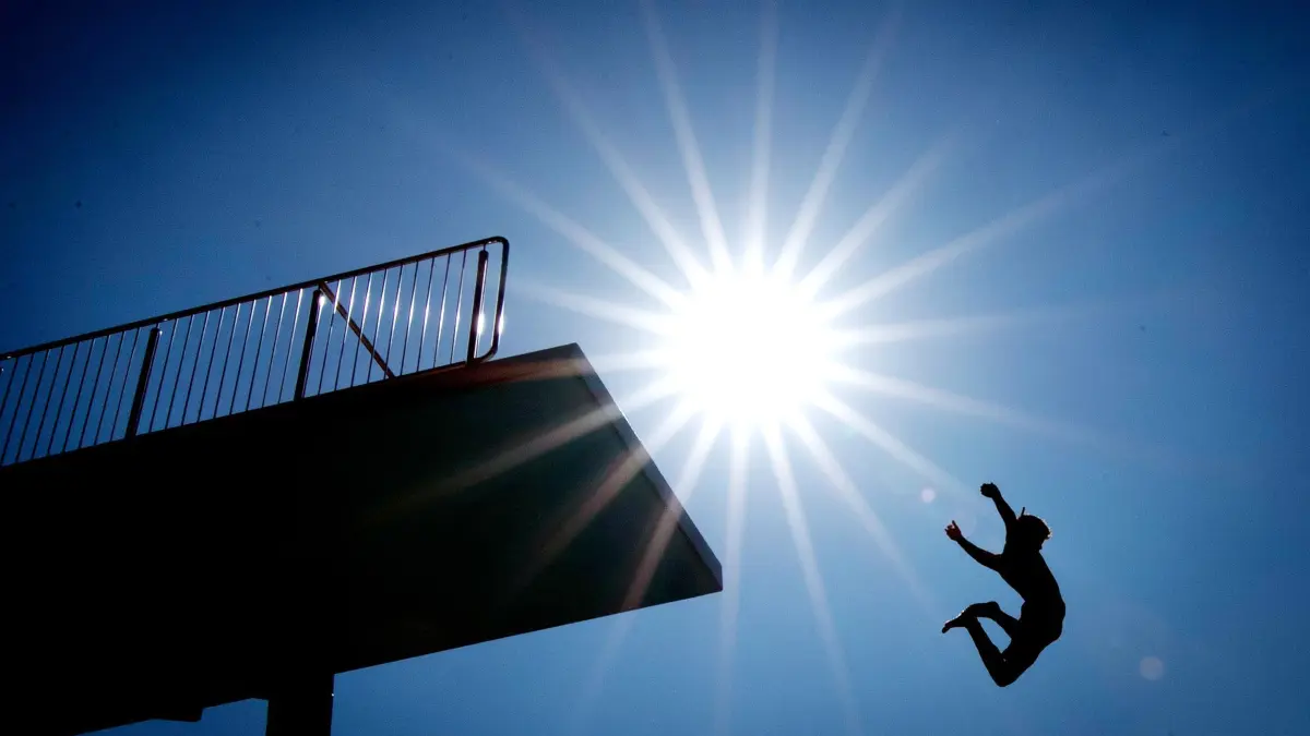 Freibad: ARCHIV - 24.07.2019, Nordrhein-Westfalen, Bielefeld: Ein Badegast springt vom 10-Meter-Turm in einem Freibad. (zu dpa: «Heißes Wochenende in NRW – Temperaturen über 30 Grad») Foto: Friso Gentsch/dpa +++ dpa-Bildfunk +++