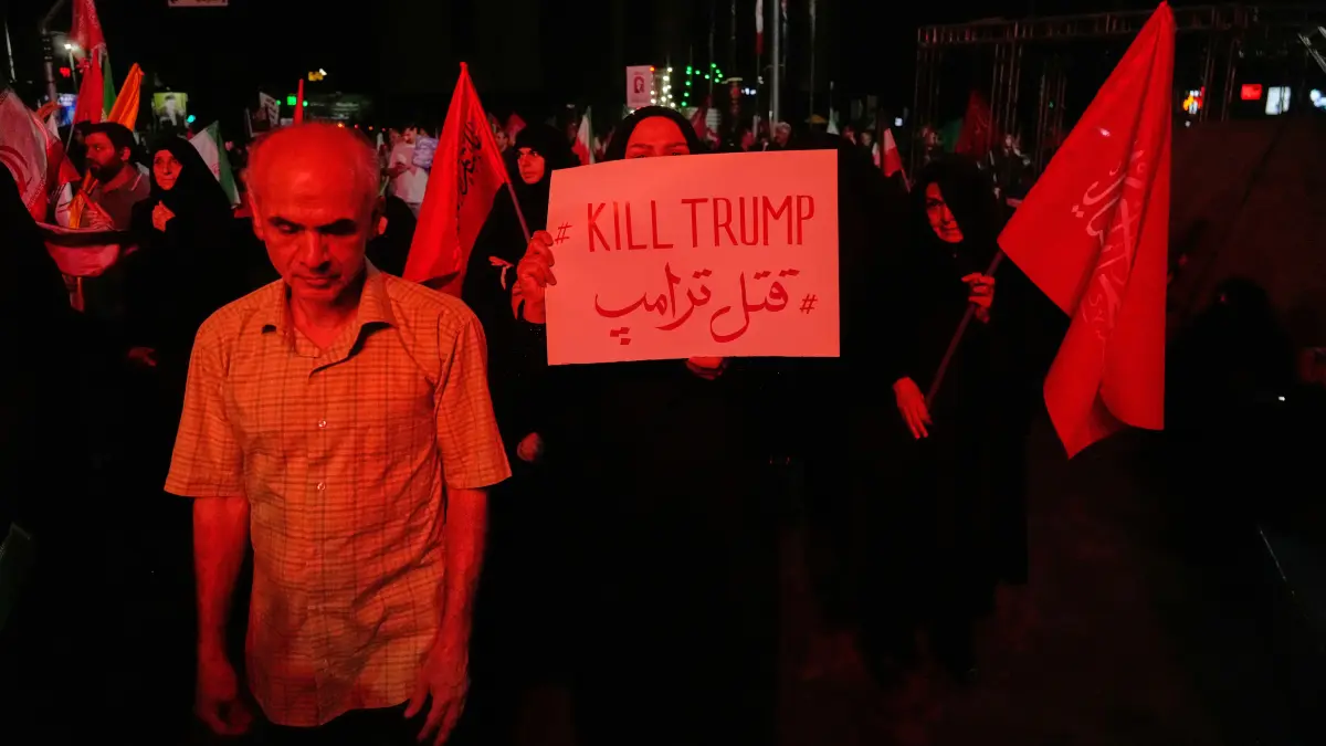 Eine regierungsfreundliche Demonstrantin hält am 11. Juli2026 bei einer Gedenkveranstaltung für den verstorbenen obersten Führer des Iran, Chamenei, auf einem Platz in Teheran ein Anti-Trump-Plakat hoch.