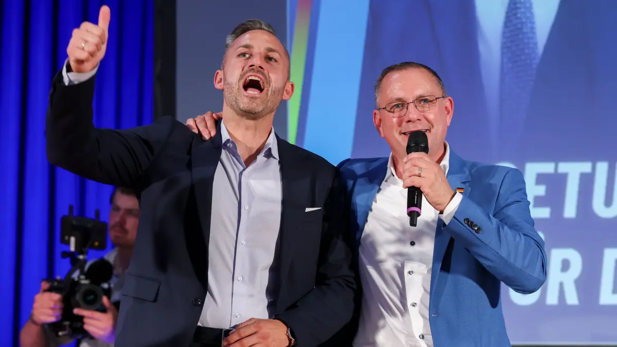 AfD-Veranstaltung in Dessau-Roßlau: 14.07.2026, Sachsen-Anhalt, Dessau-Roßlau: Ulrich Siegmund (l, AfD), Spitzenkandidat für die Landtagswahl am 6. September, und Tino Chrupalla (AfD), Bundesvorsitzender, umarmen sich auf einer Veranstaltung der AfD Sachsen-Anhalt. Foto: Jan Woitas/dpa +++ dpa-Bildfunk +++