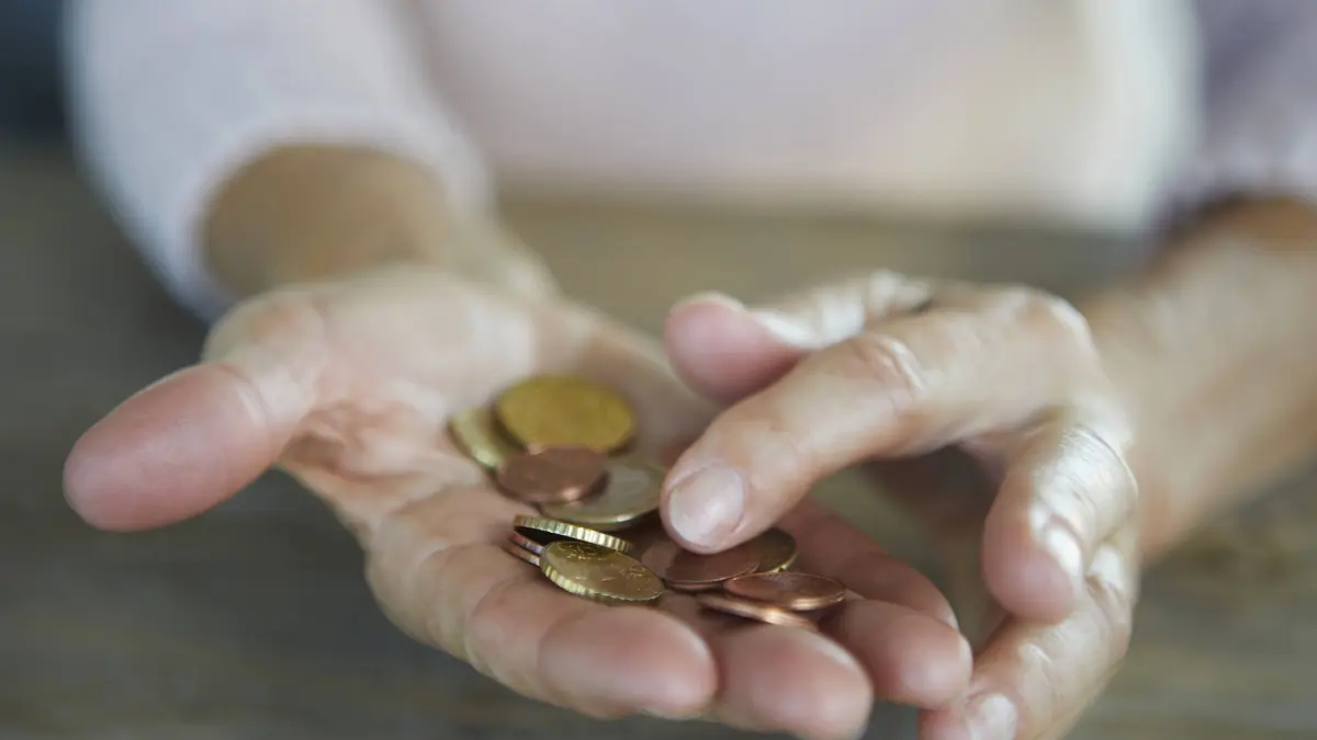 Hand holding coins representing poverty and financial hardship model released, Symbolfoto, RBF10230