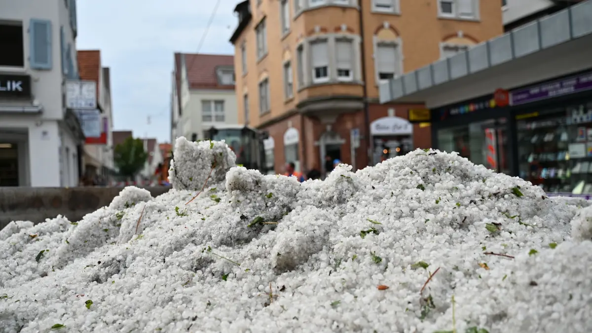 Unwetter in Baden-Württemberg - Hagel: 15.07.2026, Baden-Württemberg, Reutlingen: Hagelkörner liegen nach einem Unwetter in einem Container in der Innenstadt. Mitarbeiter der Stadtreinigung haben die Hagelkörner bei Aufräumarbeiten in den Container zum Abtransport geschüttet. Foto: Jennifer Kramer/dpa +++ dpa-Bildfunk +++