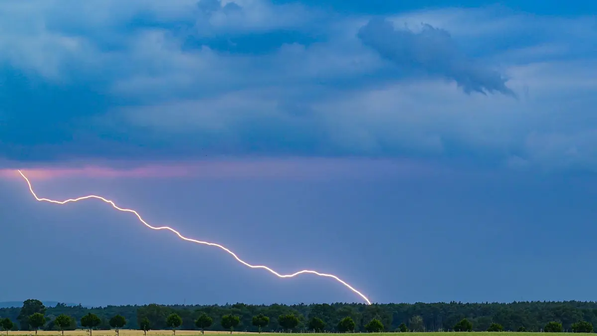 Gewitter über Brandenburg: ARCHIV - 20.06.2026, Brandenburg, Petersdorf: Ein Blitz leuchtet vor dunklen Gewitterwolken über der Landschaft im östlichen Brandenburg. (zu dpa: «Gewitter und Unwetter über Berlin und Brandenburg erwartet») Foto: Patrick Pleul/dpa +++ dpa-Bildfunk +++