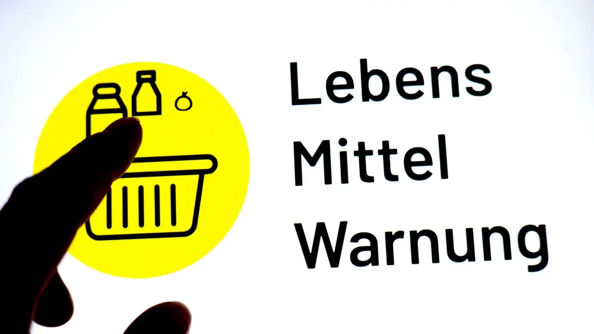 Lebensmittelwarnung: ILLUSTRATION - 17.03.2026, Bremen: Eine Person hält einen Finger vor einen Monitor, auf dem das Logo der App «Lebensmittelwarnung» zu sehen ist. (zu dpa: «Durchfall-Risiko: Rückruf für Bio-Beerenmischung von Lidl») Foto: Sina Schuldt/dpa +++ dpa-Bildfunk +++